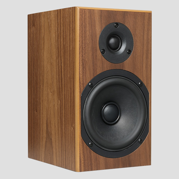 A single Loon in black walnut, three-quarter view with the grille removed: the mitred cabinet corner, the woofer in its black octagonal basket and the recessed soft dome tweeter