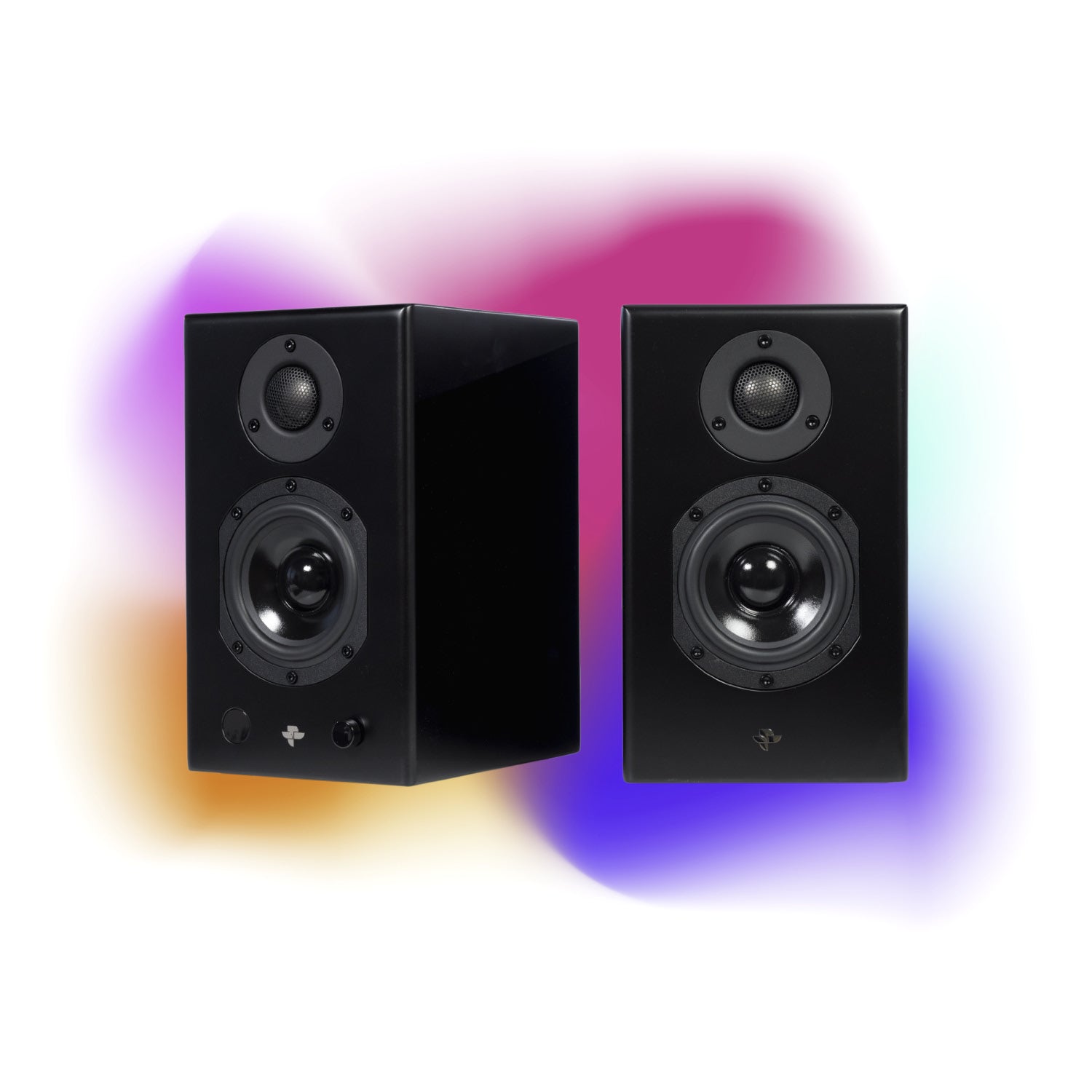 The Kin Play Mini pair in satin black, grilles off, against a coloured glow: the active cabinet with its control knob beside the passive one